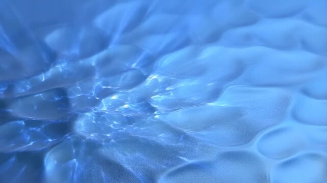 Slow motion zoom of shallow water rippling over sandy seabed with light caustics and refracted beams underwater close up