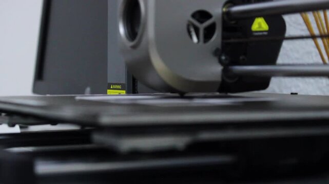 A 3D printer is printing a plastic silhouette with white threads inside a robotics club in Neiva, Huila, Colombia. Concept of science and technology 