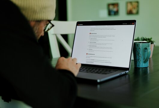 Older male university student receives alert warning notification for violating academic integrity policies by using AI chatbot for assignment concept