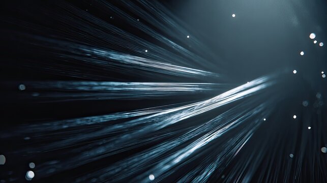 Fiber optic cables move quickly against a dark background, showing a complex network of light trails representing modern high speed data transmission and digital communication