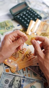 Hands toss and rotate BTC bitcoin against the dollars and euros