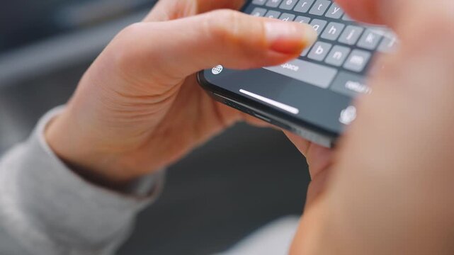 Female hands typing text on smartphone close-up.