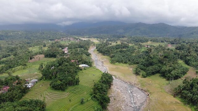 Agam, Indonesia - April 3rd 2026: Aerial Drone Forward Tracking of Salareh Aia Flash Flood Aftermath: Widened River, Massive Boulders, and Destroyed Village Houses in Disaster Zone