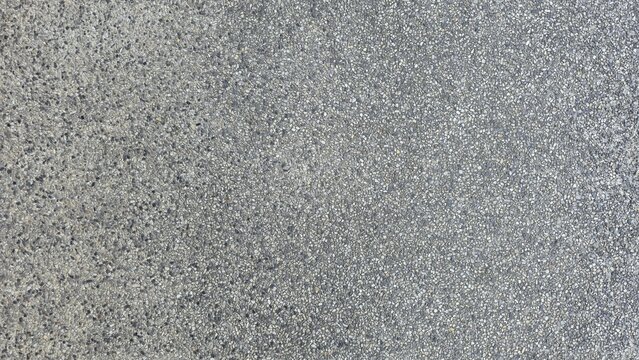 Gray gravel concrete floor, road surface, walkway surface, small gravel road surface, texture, and background. Gray exposed aggregate concrete texture with fine pebbles.