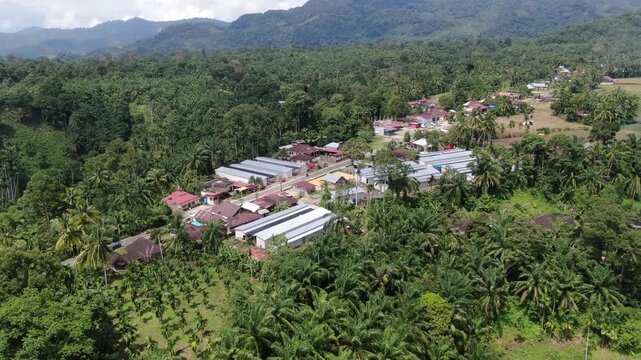 Agam, Indonesia - April 3rd 2026: Aerial View of Temporary Housing Shelters and Village Settlements Amidst Plantations and Main Road in Salareh Aia: Post-Flash Flood Recovery and Infrastructure