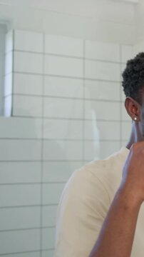 Vertical video: Gripping toothbrush man brushing teeth in bathroom making foam to clean mouth
