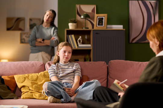 Teenage girl attending family therapy session while mother observing, discussing emotions with counselor at home. Suitable for mental health, parenting support, counseling promotion