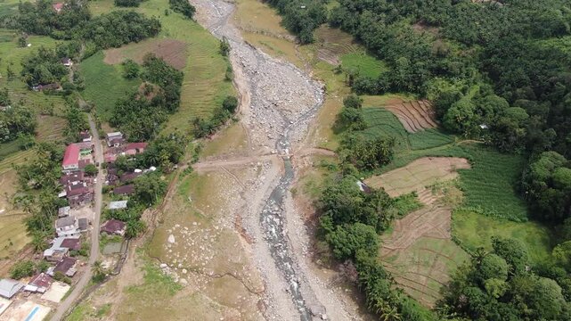 Agam, Indonesia - April 3rd 2026: Aerial Top-Down View Descending Toward Emergency Bridge Over Rocky Riverbed in Salareh Aia, Post-Flash Flood Infrastructure and Disaster Recovery Detail