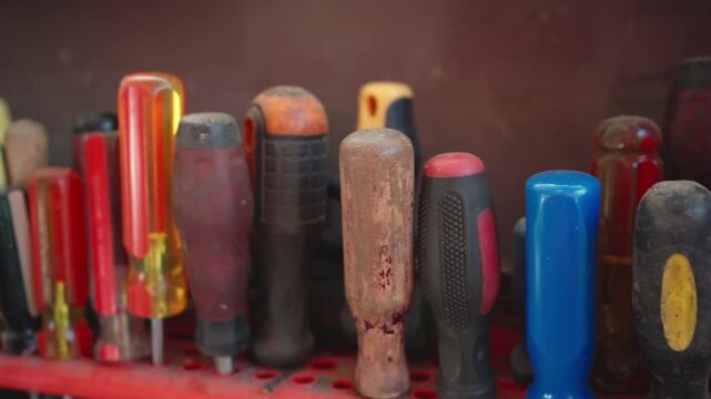 A well-organized assortment of colorful screwdrivers rests neatly in a row, a visual representation of tools of trade. The shot is perfect for illustrating concepts of tools and the industry.