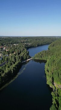 Scenic aerial drone view of Kaukaj&auml;rvi lake in Kangasala, Finland, captured on a bright sunny summer day. Calm blue water surrounded by lush green forests and natural landscapes, showcasing the beauty