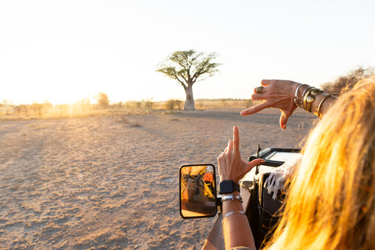 woman framing a baobab tree with her hands, Makgadikgadi National Park, Botswana, Africa