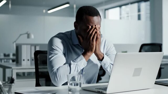 Stressed Businessman Experiencing Overwhelm At His Office Desk, Feeling Frustrated