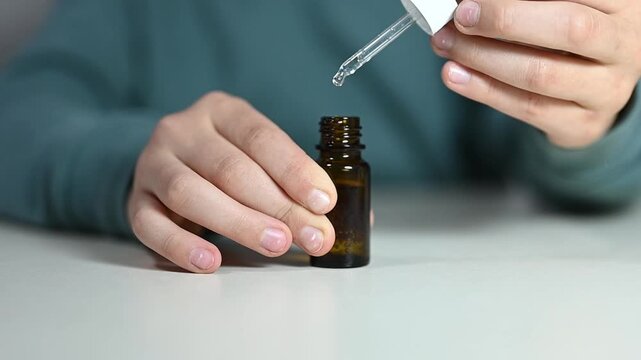 Opening a small glass bottle for oil or liquid with two hands in a simple indoor space