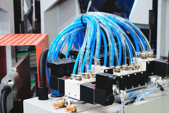 Pneumatic drives of industrial machines and conveyors, many pipes connected to  drive concept industrial background.