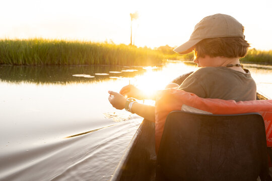 child in traditional makoro boat, navigating the Okavango Delta, Botswana, Africa