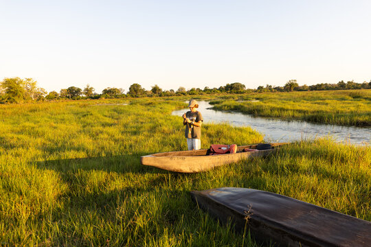child in traditional makoro boat, navigating the Okavango Delta, Botswana, Africa