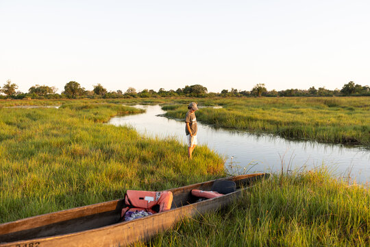 child in traditional makoro boat, navigating the Okavango Delta, Botswana, Africa