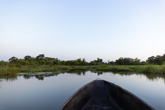 child in traditional makoro boat, navigating the Okavango Delta, Botswana, Africa