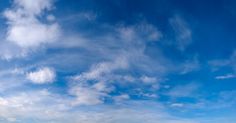 Obraz premium heaven skies blue and clear, with thin, puffy, transparent clouds. and moon is visible through them. sun shines brightly, making sky even brighter. scene is peaceful and serene