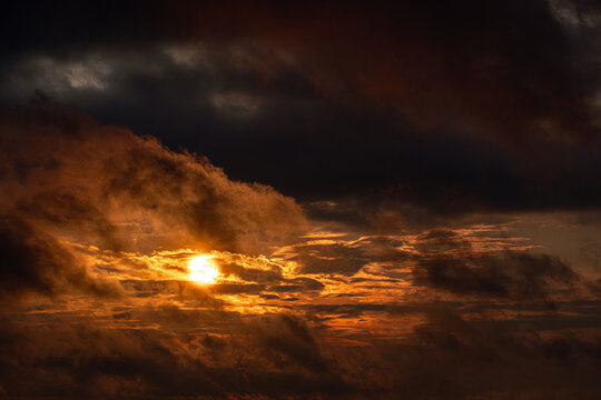 View of a dramatic sunset with golden light breaking through dark, heavy storm clouds over Kyiv, Kyiv city, Ukraine.