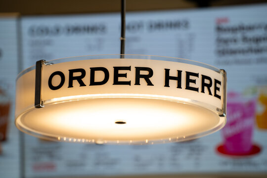 Close up of Order Here sign inside cafe counter area.