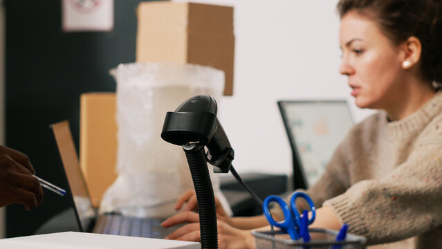 Two employees packing goods in boxes, preparing orders for retail store shipment and distribution. Team of diverse people working on shpping merchandise, verifying stock inventory.