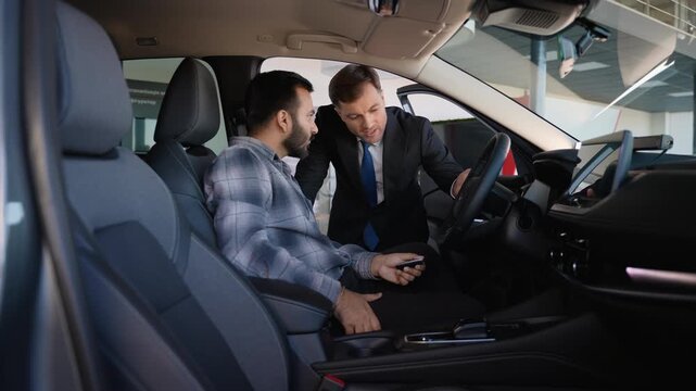 Car salesman explaining new vehicle features to Indian customer