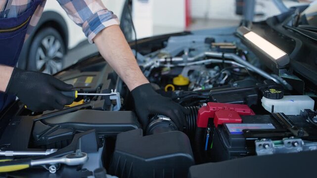 Mechanic repairing a car engine under the hood in a modern workshop