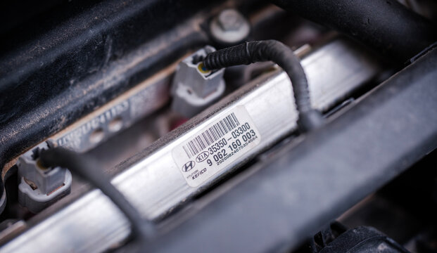 High detail technical close up revealing the metallic fuel injection distribution rail and attached electronic wiring harnesses positioned across the engine block of a hyundai i20