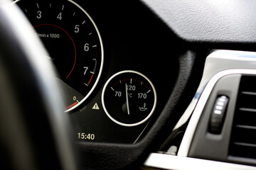 Tachometer and oil temperature gauge on a modern car dashboard, close-up view of illuminated instrument panel with precise indicators and digital display. © Vladislav12