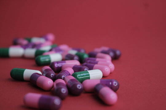 C&aacute;psulas blandas para la salud colocadas sobre un fondo rojo.