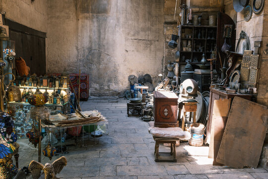View of Khan el-Khalili market stall with traditional lamps, antiques, and metalwork inside a historic stone building in El-Gamaleya, Cairo Governorate, Egypt.