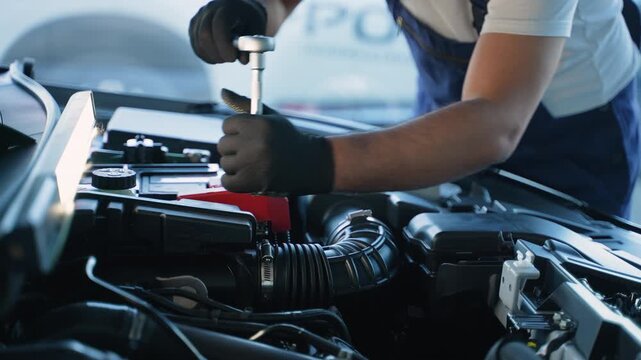 Mechanic using socket wrench repairing car engine