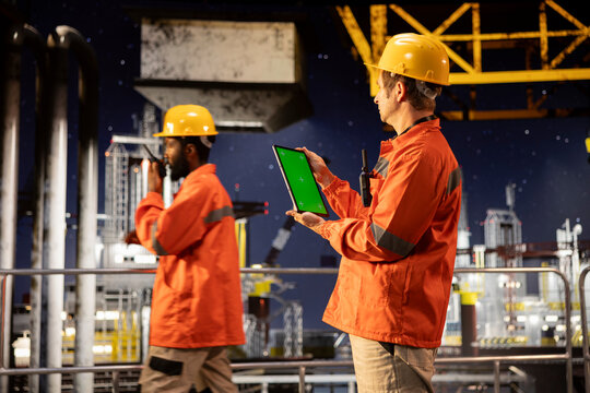Vertical chroma key display with engineer conducting offshore inspection, monitoring emissions and risk factors to guarantee efficient oil and fuel extraction activity on oil rig platform.