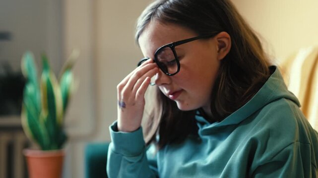 Tired little girl putting on glasses with exhausted eyes, overworked child student rubbing eyes, 4K 10-bit