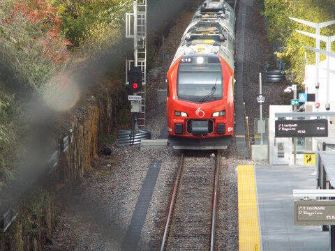 Ottawa, Ontario, Canada &ndash; August 02, 2025: A red and silver OC Transpo train, identifiable by the "C13" marking, approaches a station platform.