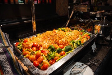 Obraz premium a large, golden-brown lattice-topped savory pastry roll displayed on a silver platter