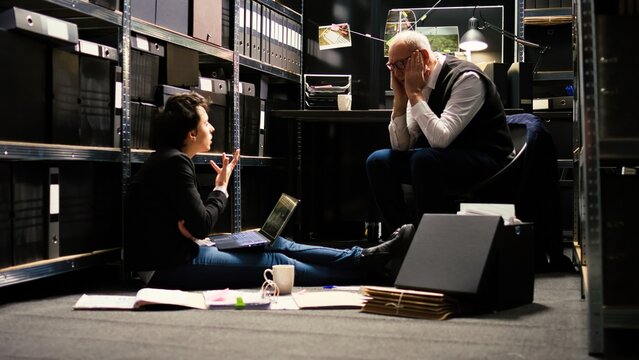 Agents feeling tired of criminal case, discussing about forensic evidence authenticity to gather more incriminating proof and solve mystery. Officers team on law enforcement duty.