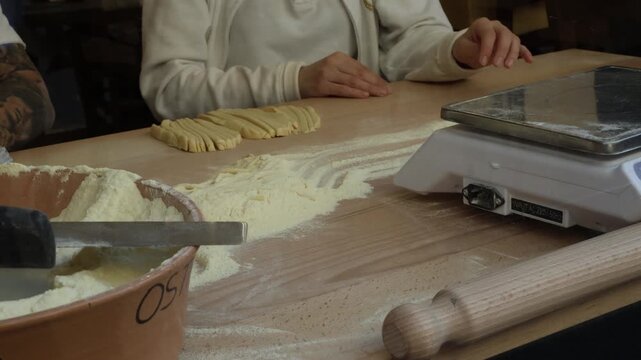 Hands making fresh homemade Italian pasta on wooden table