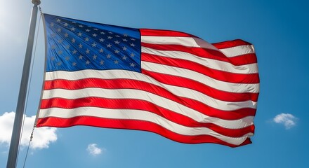 Fototapeta premium American flag waving proudly in the sunlight against a bright blue sky. The flag symbolizes the freedom, unity, and strength