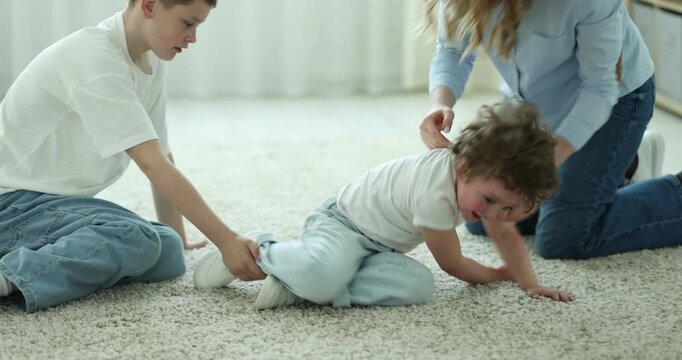 Mother and her sons having fun together at home, camera moving in