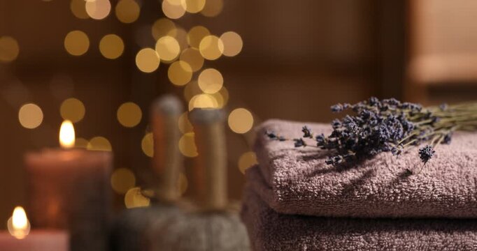 Soft clean towels and lavender flowers spinning on table indoors, closeup
