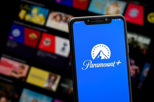 Cali, Colombia - June 12 2022: Smartphone displaying Paramount+ logo against a blurred streaming service interface with movie and show thumbnails.