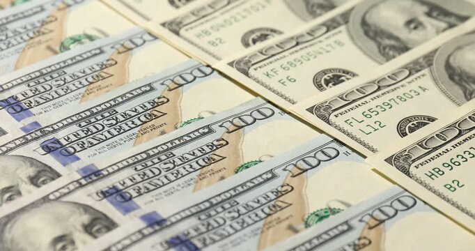 Old and new hundred dollar bills as background, closeup. Camera moving right