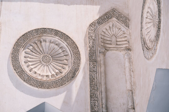 View of intricate stone carvings and circular medallions on the historic walls of Al-Azhar Mosque in Cairo, Egypt.