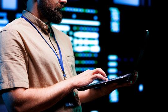 Precise technician doing checkup on interlinked computers creating server network. High tech establishment using parallel computing to perform complex computing operations and process data