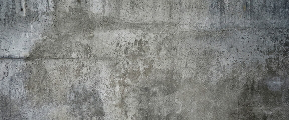 Fototapeta premium A textured, weathered concrete wall displaying various shades of gray. The surface has subtle imperfections, adding depth and interest to the overall appearance.