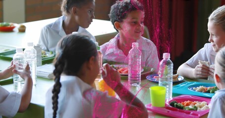 Sharing students wearing light shirts at school lunch table, with trays and water bottles © vectorfusionart