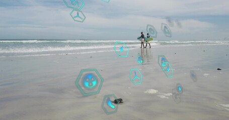 Fototapeta premium Walking two men carrying yellow surfboard along wet sand, wearing rashguards, holograms, copy space