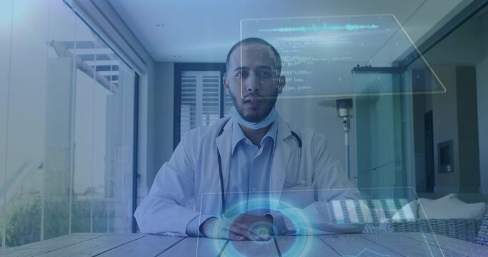 Sitting mid adult Asian physician consulting with holo UI at terrace white lab coat and stethoscope